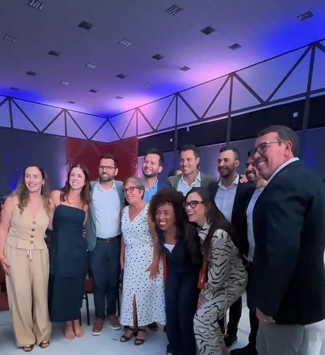 Michele Marques em foto de grupo com outras pessoas em um evento